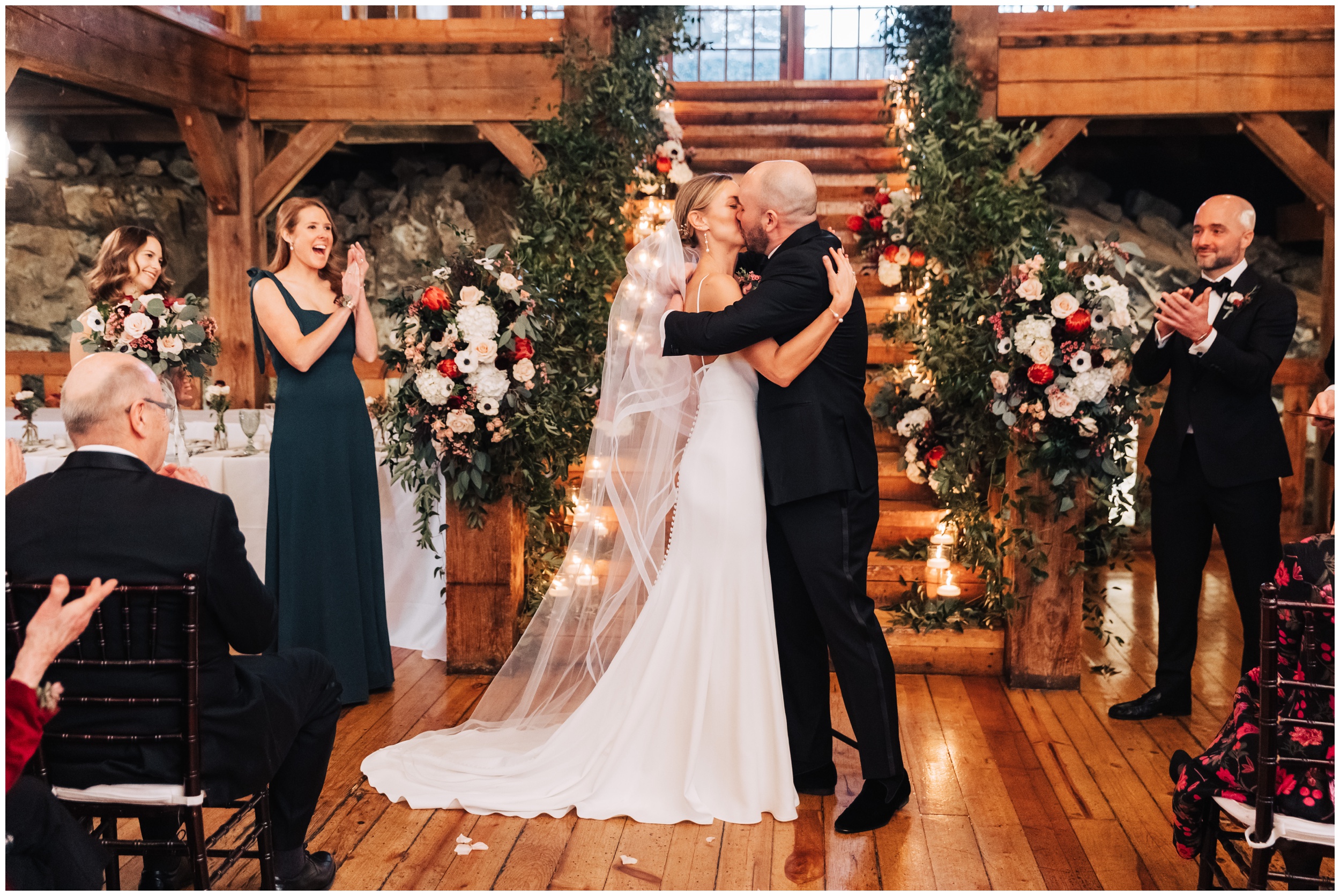 winter wedding ceremony in the barn at red lion in cohasset ma bride and groom kiss